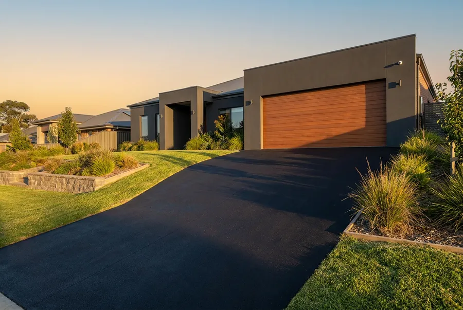 New asphalt driveway on a sloped block at a modern home